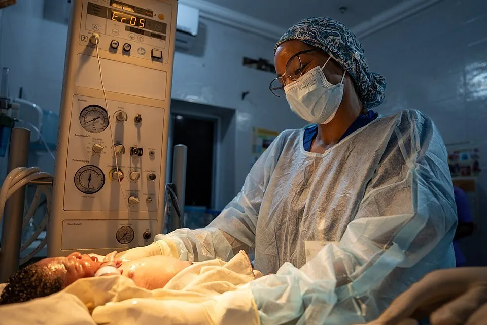 A midwife caring for a newborn baby in a maternity ward in Ghana